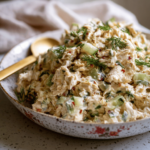 Close-up of creamy dill pickle chicken salad with chopped pickles and herbs